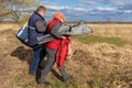 a man and a woman walk with things from a picnic