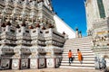 A man and woman walk up the stairs at the Prang of Arun Temple, Bangkok.