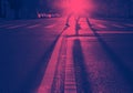 Man and woman walking across the street in New York City with the light of sunset casting long shadows in pink and blue Royalty Free Stock Photo