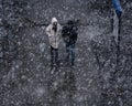 People walking along the during heavy snowfall