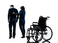 Man with woman walking away from wheelchair silhouette Royalty Free Stock Photo