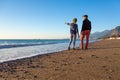 Man and Woman walking on Beach and enjoying Sea View