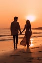 A man and a woman walking on a beach at sunset. Generative AI image. Royalty Free Stock Photo