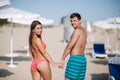 Man and woman walking through the beach and turn around to look at the sea. Sexy woman