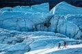 Man and woman walking narrow ridge on the Matanuska Glacier in Remote Alaska. Large crevasses and fins break up the ice all around Royalty Free Stock Photo