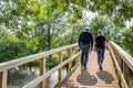 Man and woman walking over a simple wooden bridge Royalty Free Stock Photo