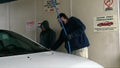 Man and Woman Wash Car in Self-Serve Car Wash (Winter)