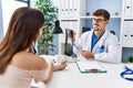 Man and woman wearing doctor uniform having medical consultation showing xray at clinic Royalty Free Stock Photo