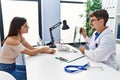 Man and woman wearing doctor uniform having medical consultation showing xray at clinic Royalty Free Stock Photo