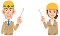 A man and a woman wearing a helmet wearing beige work clothes explained by a pointer