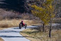 Man or woman wearing a magenta colored jacket and purple helmet riding a three wheeled bicycle Royalty Free Stock Photo