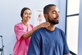 Man and woman wearing physiotherapist uniform having rehab session massaging neck at physiotherpy clinic Royalty Free Stock Photo