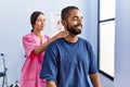 Man and woman wearing physiotherapist uniform having rehab session massaging neck at physiotherpy clinic Royalty Free Stock Photo