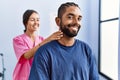 Man and woman wearing physiotherapist uniform having rehab session massaging neck at physiotherpy clinic Royalty Free Stock Photo