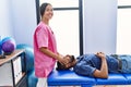 Man and woman wearing physiotherapist uniform having reiki session at physiotherpy clinic Royalty Free Stock Photo