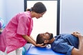 Man and woman wearing physiotherapist uniform having reiki session at physiotherpy clinic Royalty Free Stock Photo