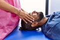 Man and woman wearing physiotherapist uniform having reiki session at physiotherpy clinic Royalty Free Stock Photo