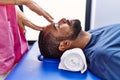 Man and woman wearing physiotherapist uniform having reiki session at physiotherpy clinic Royalty Free Stock Photo