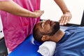 Man and woman wearing physiotherapist uniform having reiki session at physiotherpy clinic Royalty Free Stock Photo