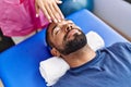 Man and woman wearing physiotherapist uniform having reiki session at physiotherpy clinic Royalty Free Stock Photo