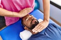 Man and woman wearing physiotherapist uniform having reiki session at physiotherpy clinic Royalty Free Stock Photo