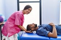 Man and woman wearing physiotherapist uniform having reiki session at physiotherpy clinic Royalty Free Stock Photo