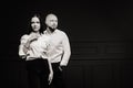 A man and a woman in white shirts on a black background.A couple in love in the studio interior.Black and white photo Royalty Free Stock Photo