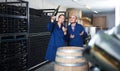 Man and woman winemakers in wine cellar