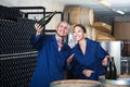 Man and woman winemakers in wine cellar