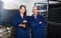 Man and woman winemakers in wine cellar