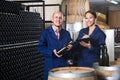 Man and woman winemakers in wine cellar