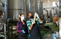 Two winemakers checking winemaking process at factory