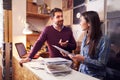 Man and woman working behind the counter at a record shop Royalty Free Stock Photo