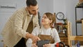 Man and woman working together in a carpentry workshop discussing a project on a tablet Royalty Free Stock Photo