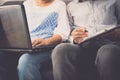 Man and woman workmate discussing together while using laptop in office