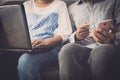 Man and woman workmate discussing together while using laptop and mobile phone in office