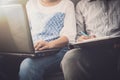 Man and woman workmate discussing together while using laptop in office