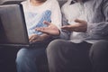 Man and woman workmate discussing together while using laptop in office