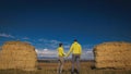 Man and woman in yellow green sportswear. Lovely couple of travelers hug and kiss near old stone enjoying highland