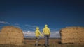 Man and woman in yellow green sportswear. Lovely couple of travelers hug and kiss near old stone enjoying highland Royalty Free Stock Photo