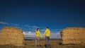 Man and woman in yellow green sportswear. Lovely couple of travelers hug and kiss near old stone enjoying highland Royalty Free Stock Photo