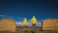 Man and woman in yellow green sportswear. Lovely couple of travelers hug and kiss near old stone enjoying highland Royalty Free Stock Photo