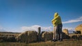 Man and woman in yellow green sportswear. Lovely couple of travelers hug and kiss near old stone enjoying highland Royalty Free Stock Photo