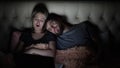 Man and woman, young couple watching boring movie on laptop in bed before bedtime Royalty Free Stock Photo