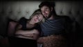 Man and woman, young couple watching boring movie on laptop in bed before bedtime Royalty Free Stock Photo