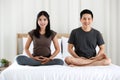 Man and woman Buddhist sitting on bed in the bedroom and doing meditation in Buddhism religion style together. The idea for faith Royalty Free Stock Photo