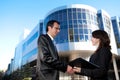 Man and woman in suits shake hands