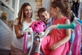 Man and woman buying new bicycle and helmet for little girl in bike shop Royalty Free Stock Photo