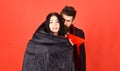 Man and woman dressed like vampire, demon, red background. Couple in love relations, perfect match. Girl on scared face Royalty Free Stock Photo