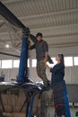 Handsome male and beautiful female working together with helicopter in garage Royalty Free Stock Photo